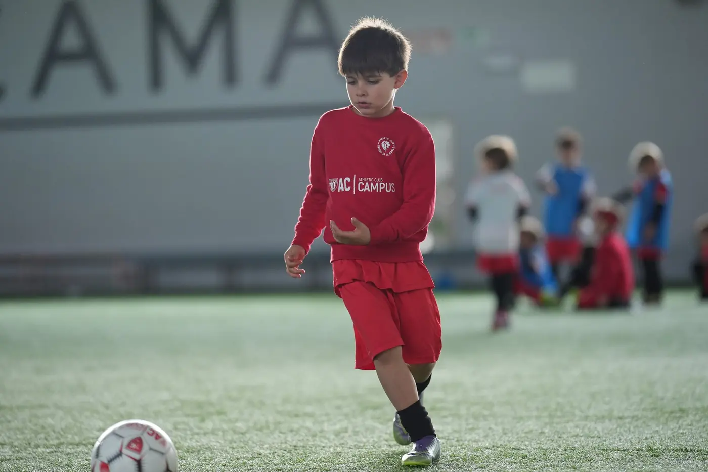 Jugador del campus con la sudadera roja del AC Campus en los campos de Lezama