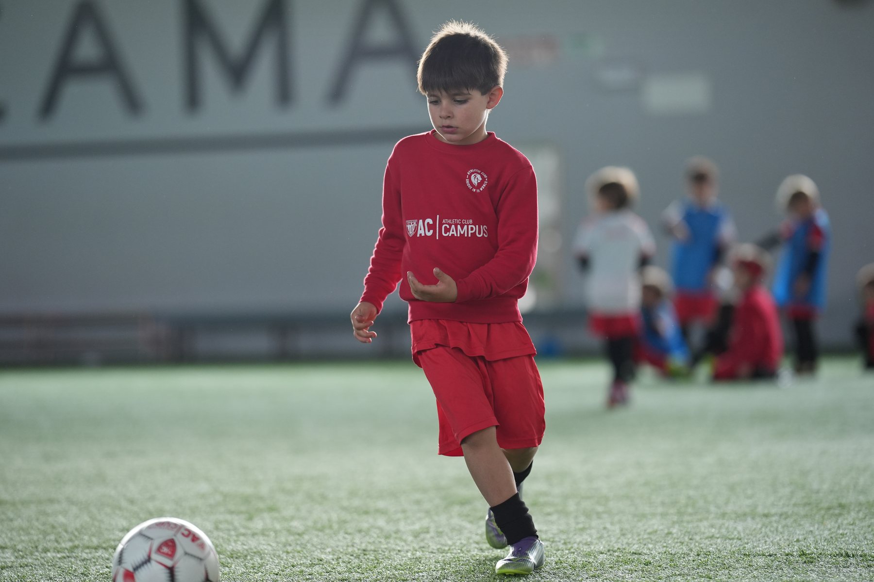 Jugador del campus con la sudadera roja del AC Campus en los campos de Lezama